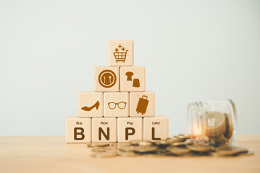 bloque de madera con icono BNPL con iconos de compras en línea monedas borrosas. Comprar ahora pagar más tarde el concepto de compra online