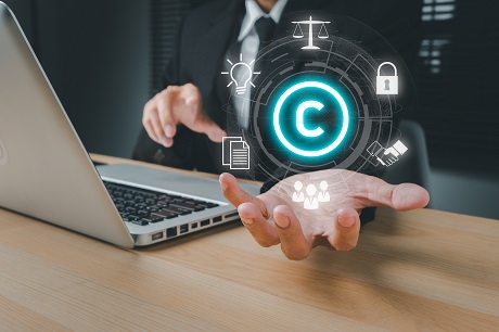 Copyright or patent concept, Business person hand holding VR screen copyright icon with blue bokeh background, Copyleft trademark license, Creation ownership against piracy crime.