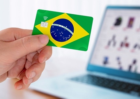 Hands holding plastic credit card and using laptop. Online shopping concept in Brazil.