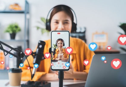 Vlogger live streaming podcast review on social media, Young Asian woman use microphones wear headphones with laptop record video. Content creator concept.